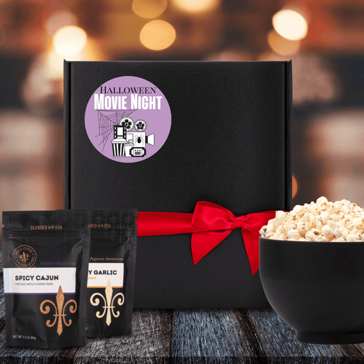 Black gift box with purple label. Black and white movie themed image with spider web behind. Halloween Movie Night in black and white. Dell Cove Spices