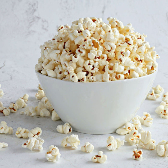 White bowl filled with popcorn on a light gray background - Dell Cove Spices