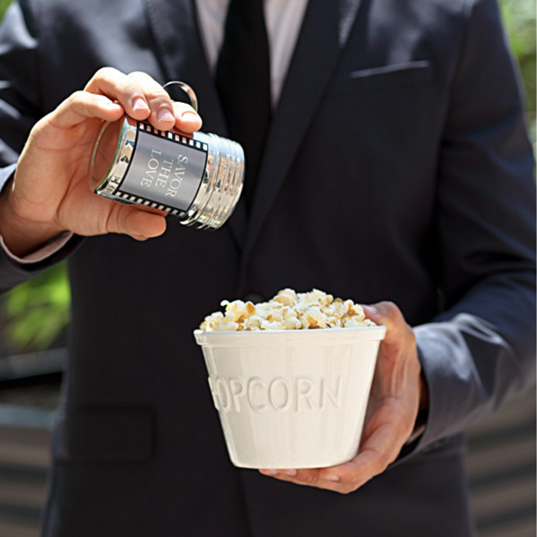 Baby white popcorn in white popcorn bowl and seasoning being sprinkled on bowl by groom - dell cove spices
