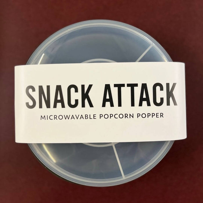 Black silicone microwave popcorn popper packaged with Snack Attack belly band and clear measuring lid
