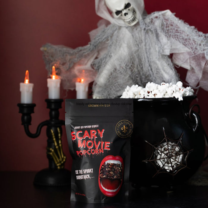 Scary Movie Popcorn bag with a skeleton and popcorn in a cauldron against a red background for Halloween gift ideas.