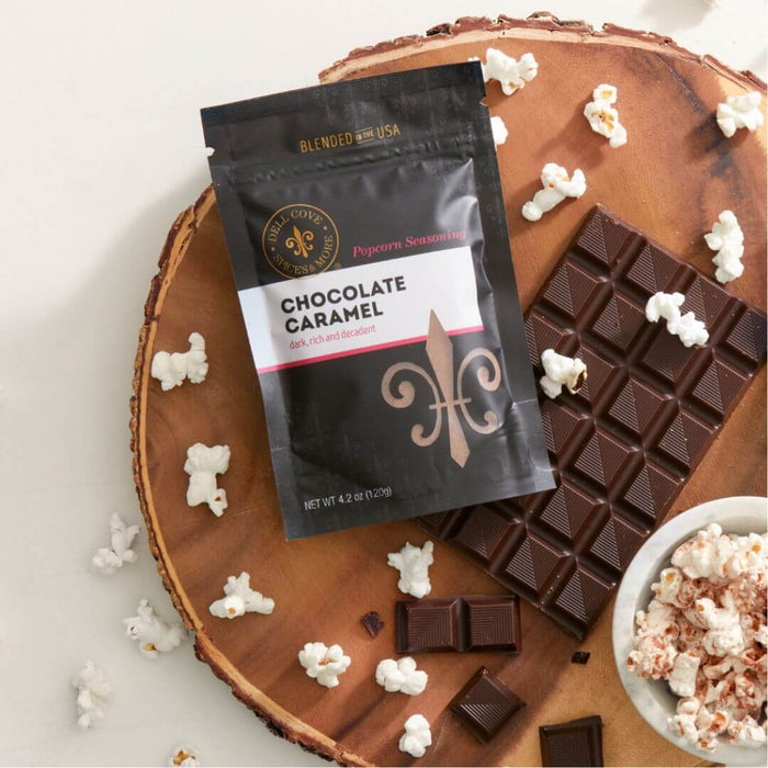 Dell Cove Chocolate Caramel Popcorn Seasoning with chocolate, popcorn and a bowl of chocolate-seasoned popcorn.