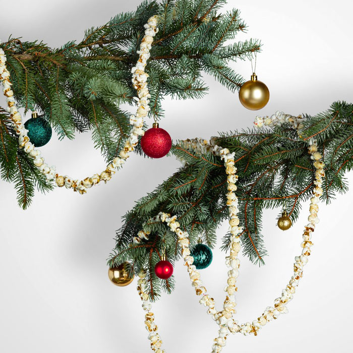 Decorative Christmas popcorn garland with ornaments on a white background