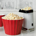 Crate & Barrel red scalloped melamine popcorn tub beside a popcorn maker