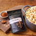 Pan of popcorn sprinkled with Dell Cove Spicy Cajun Popcorn Seasoning – spicy snacks for spice lovers with zesty Louisiana flavor