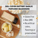 Dell Cove Buttery Garlic popcorn seasoning with garlic and butter on a wooden board.