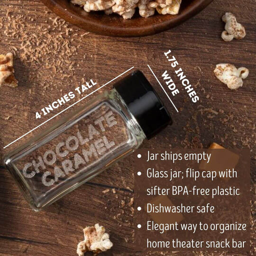 Glass spice jar etched Chocolate Caramel for chocolate caramel popcorn seasonings on a wooden surface with popcorn and chocolate and caramel pieces.