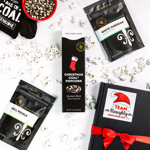 Dell Cove® Christmas Coal Popcorn Gift Set with black kernels and two popcorn seasonings in ribbon-tied holiday gift box.