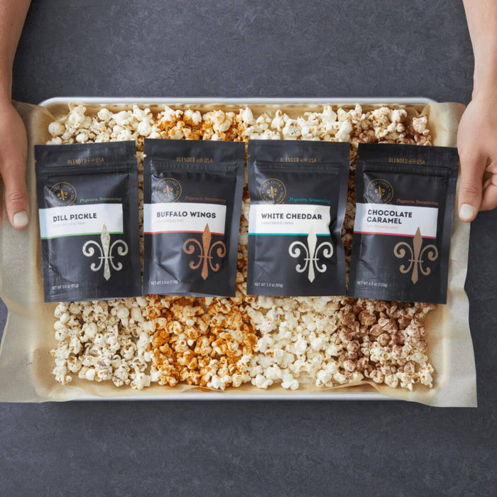 Assortment of Dell Cove® popcorn seasoning pouches showing different flavors like White Cheddar and Dill Pickle