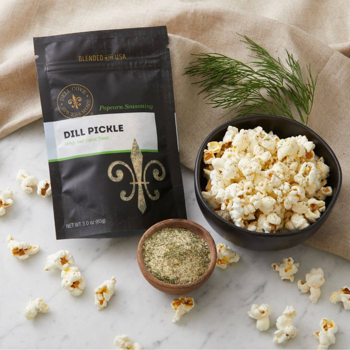 Bowl of popcorn sprinkled with Dell Cove Dill Pickle Popcorn Seasoning – zesty, tangy popcorn salt for movie night snacking.
