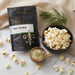 Bowl of popcorn sprinkled with Dell Cove Dill Pickle Popcorn Seasoning – zesty, tangy popcorn salt for movie night snacking.