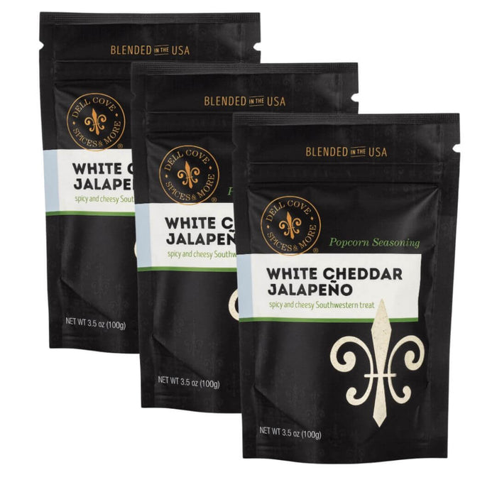 Three packages of Dell Cove Spices White Cheddar Jalapeno popcorn seasoning with a black background.