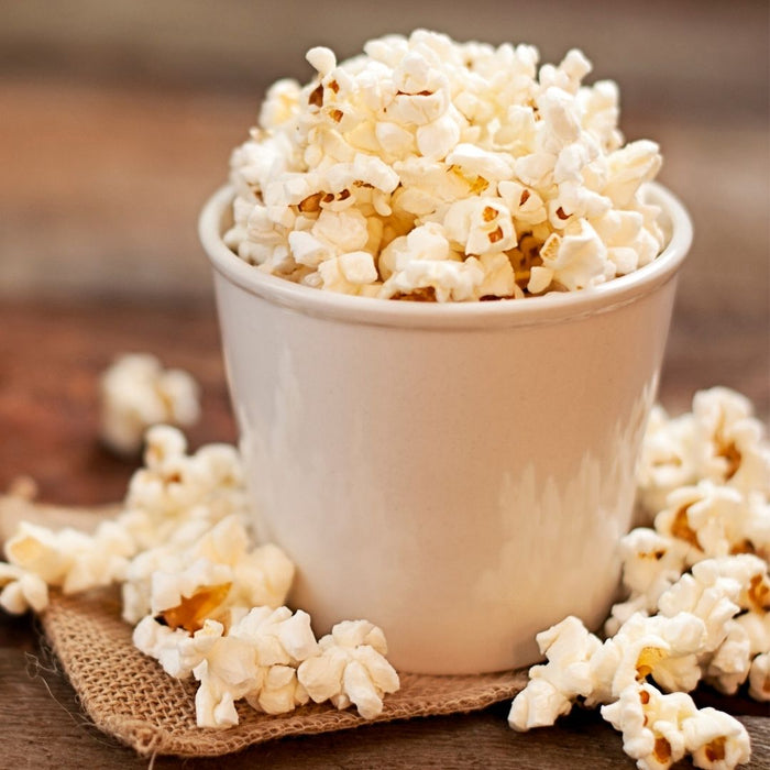 White bowl of popped popcorn on a table from Dell Cove® popcorn sampler gift set, ready for movie night