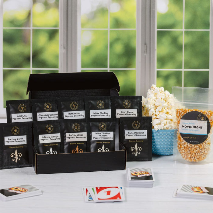 Dell Cove popcorn seasoning sampler packets with movie night kernels in lifestyle scene of Uno card game