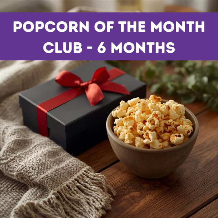 Bowl of popcorn next to a gift box with a red ribbon on a wooden surface, with text 'Popcorn of the Month Club - 6 Months' at the top.