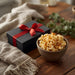 Cozy lifestyle image of Dell Cove Popcorn of the Month Club subscription gift box with bowl of gourmet popcorn — perfect monthly popcorn gift.