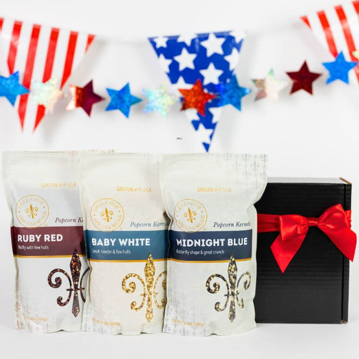 Three popcorn bags labeled 'Ruby Red', 'Baby White', and 'Midnight Blue' with a gift box in the background.