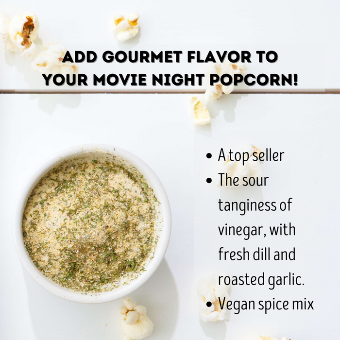 Dill Pickle popcorn seasoning in a small cup with popped popcorn - Dell Cove Spices