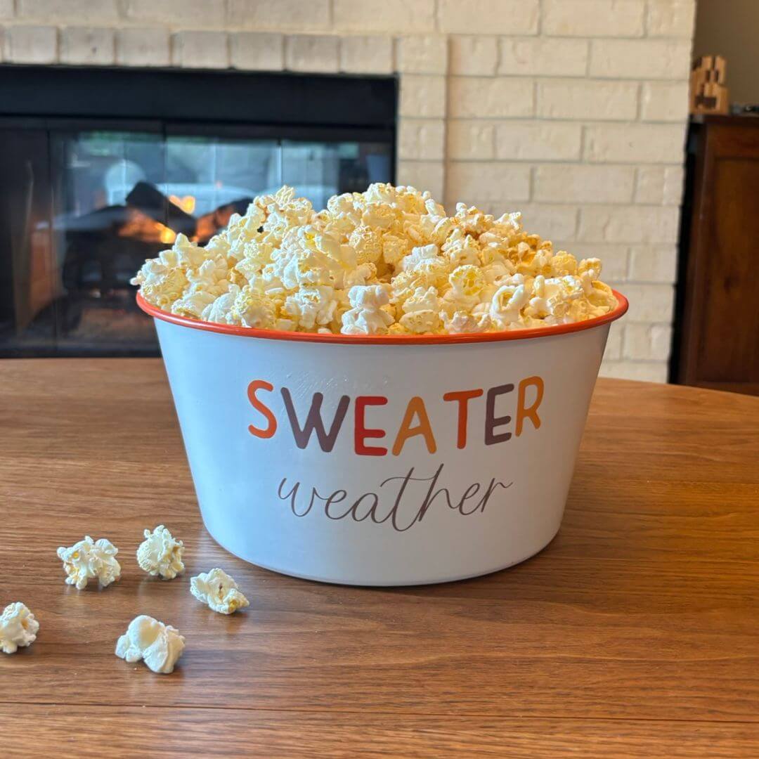 Sweater Weather enamel popcorn bowl filled with popcorn for a cozy fall movie night