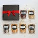 Dell Cove gourmet popcorn gift set with six varieties of popcorn kernels — Ruby Red, Baby White, Midnight Blue, Movie Night, Mushroom and Rainbow — displayed beside a black gift box tied with a red ribbon.