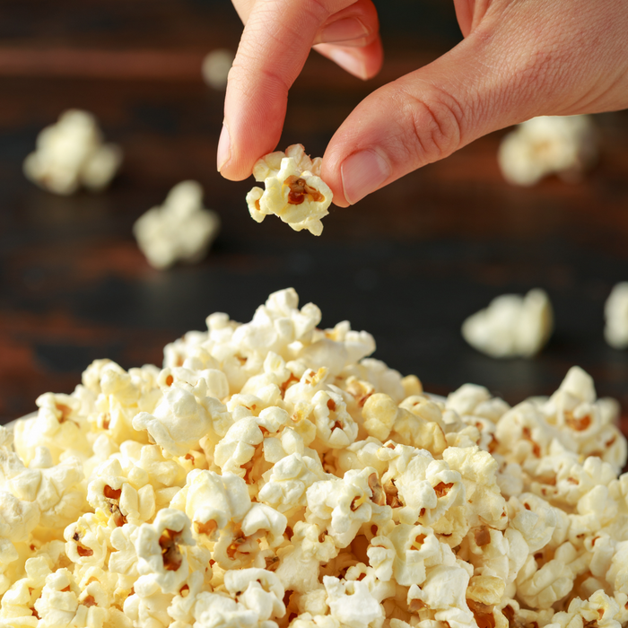 Movie Night popcorn popped and a hand holding a piece - dell cove spices