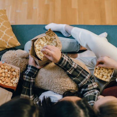 People eating Dell Cove Spices popcorn together on a couch