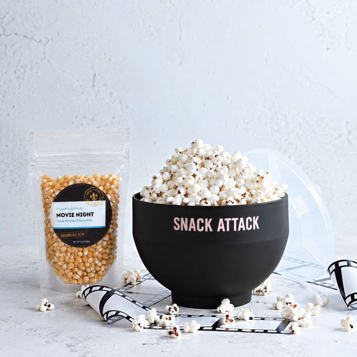 Dell Cove Movie Night popcorn kernels beside a black Snack Attack microwave popper filled with freshly popped popcorn.