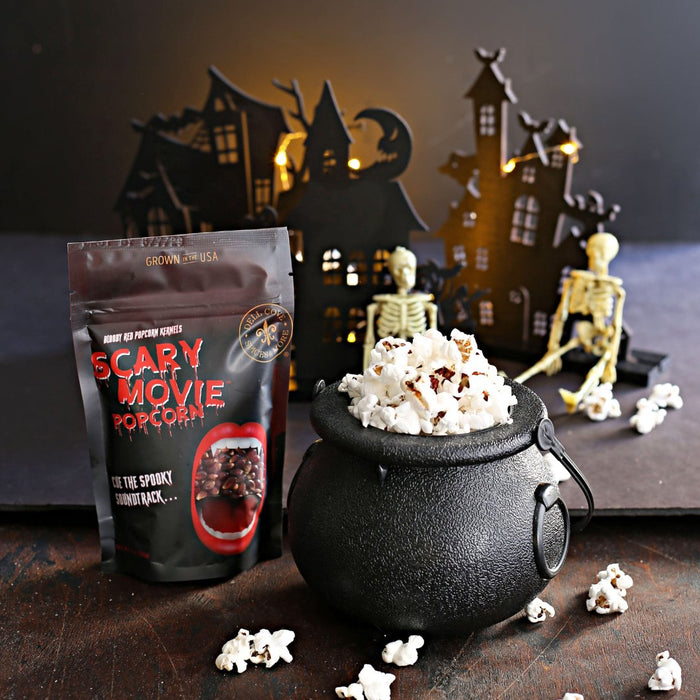 Scary Movie Popcorn packaging with a black cauldron filled with popcorn against a Halloween-themed background.