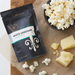 White cheddar popcorn seasoning pouch with bowl of seasoned popcorn - dell cove spices