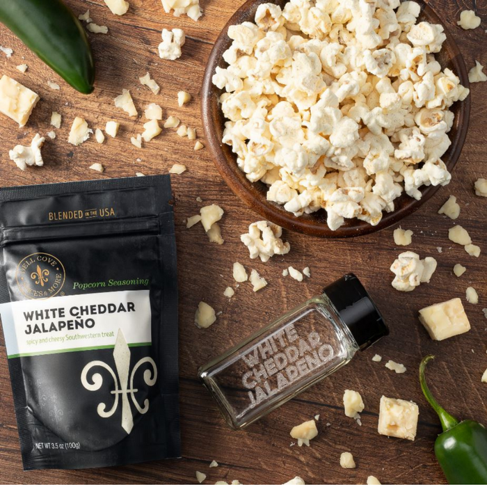 White Cheddar Jalapeno popcorn seasoning pouch with bowl of popcorn and empty spice jar - dell cove spices